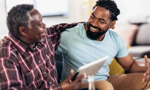 Son and father smiling with a tablet on their hands